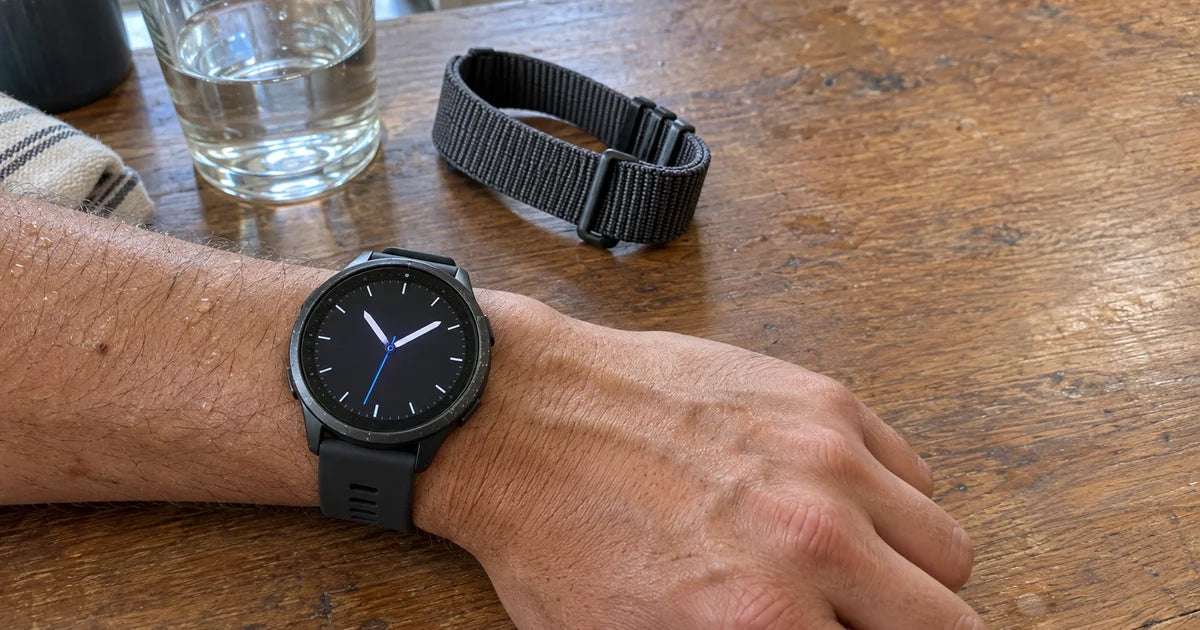 Garmin Forerunner 965 avec un bracelet silicone graphite, poignet de triathlète sur un guidon de vélo au lever du soleil Image