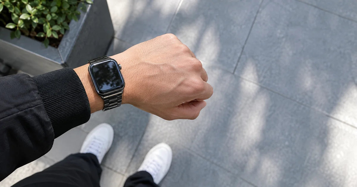 Apple Watch Ultra avec un bracelet nylon tressé vert foncé au poignet d'un homme en veste décontractée
